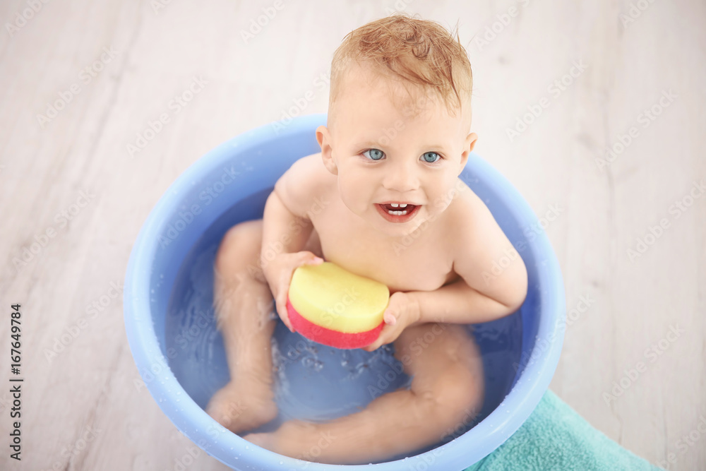 Little baby boy washing in bath basin at home Little baby boy washing in bath basin at home