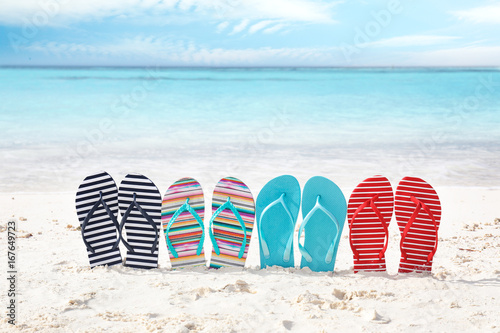 Cuadro en lienzo Colorful flip-flops on sea shore. Summer vacation concept