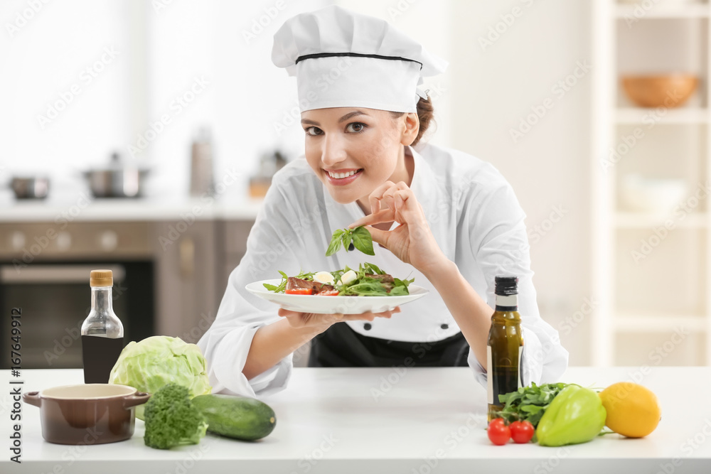 Young female chef with tasty dish in kitchen Young female chef with tasty dish in kitchen