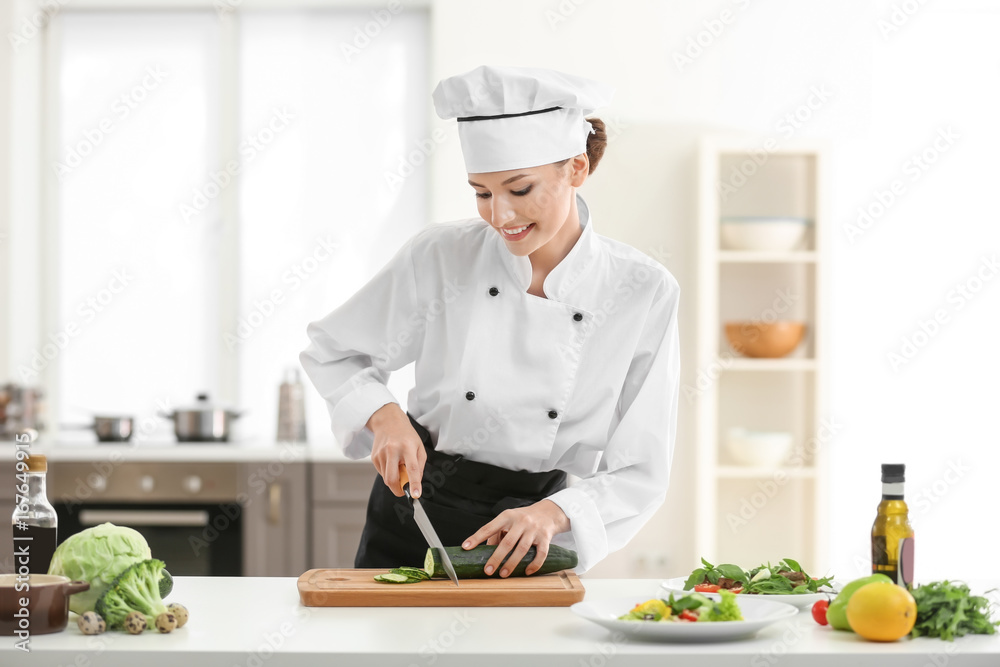 Young female chef cooking in kitchen Young female chef cooking in kitchen
