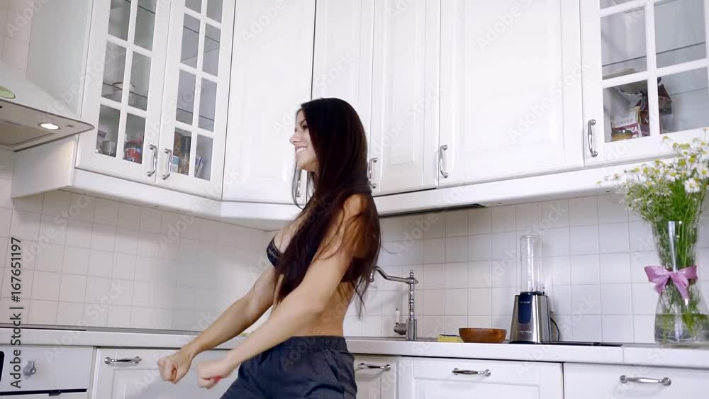 young girl with slender athletic body dancing Breasts in the morning at the kitchen with white furniture young girl with slender athletic body dancing Breasts in the morning at the kitchen with white furniture
