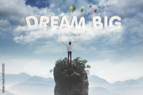 Young male looking at text of dream big photo