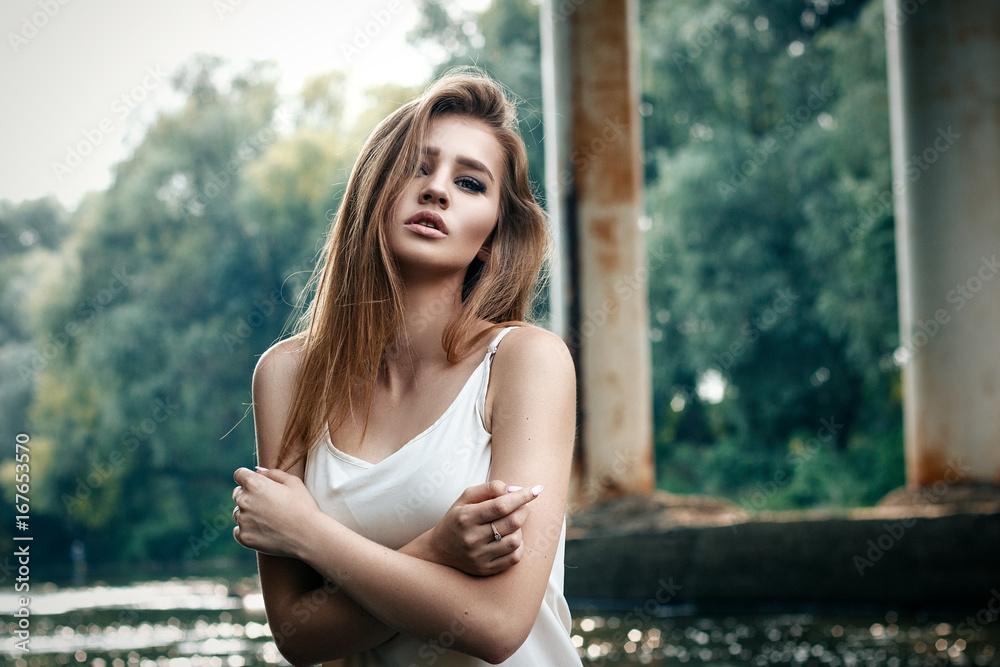 Elegant girl sitting in the water, a river or a lake with a beautiful makeup, in pinyuare