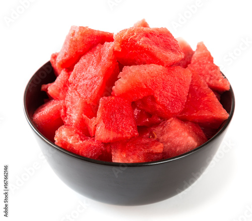 Pieces of ripe watermelon in a cup on a white background