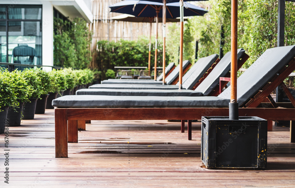 Luxury outdoor sunbathing deck chair at resort swimming pool