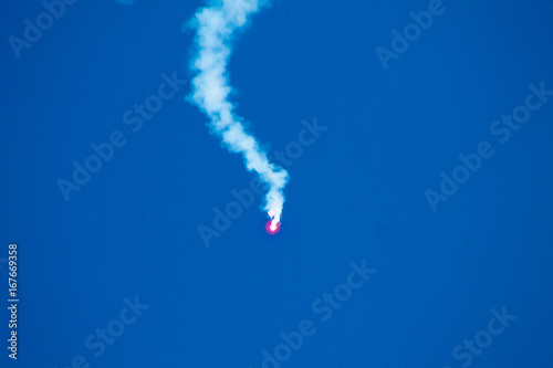 An emergency red rocket in the blue sky in an exercise