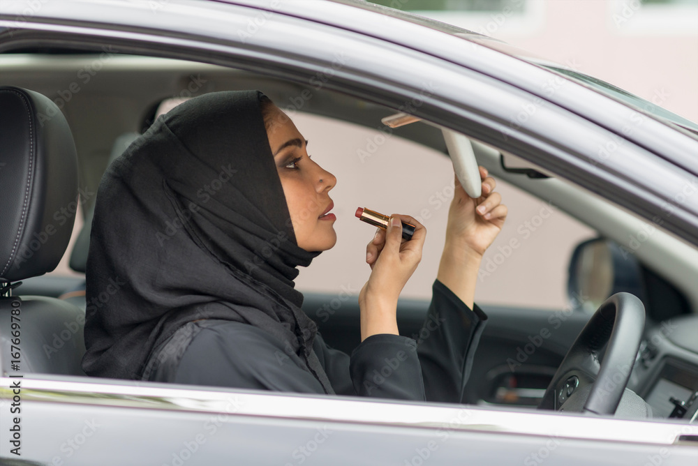 Arab women using make-up inside car. Arab women using make-up inside car.