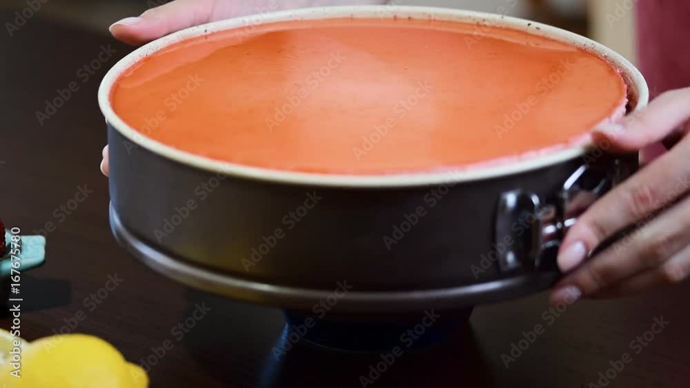 Girl remove strawberry cake from the mold on a plate. Girl remove strawberry cake from the mold on a plate.