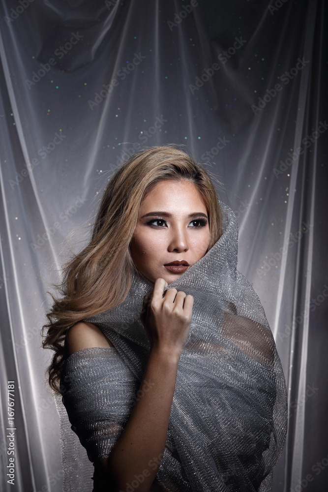 Lady in Star background with drape gray silver glitter fabric hanging, Asian blond hair woman