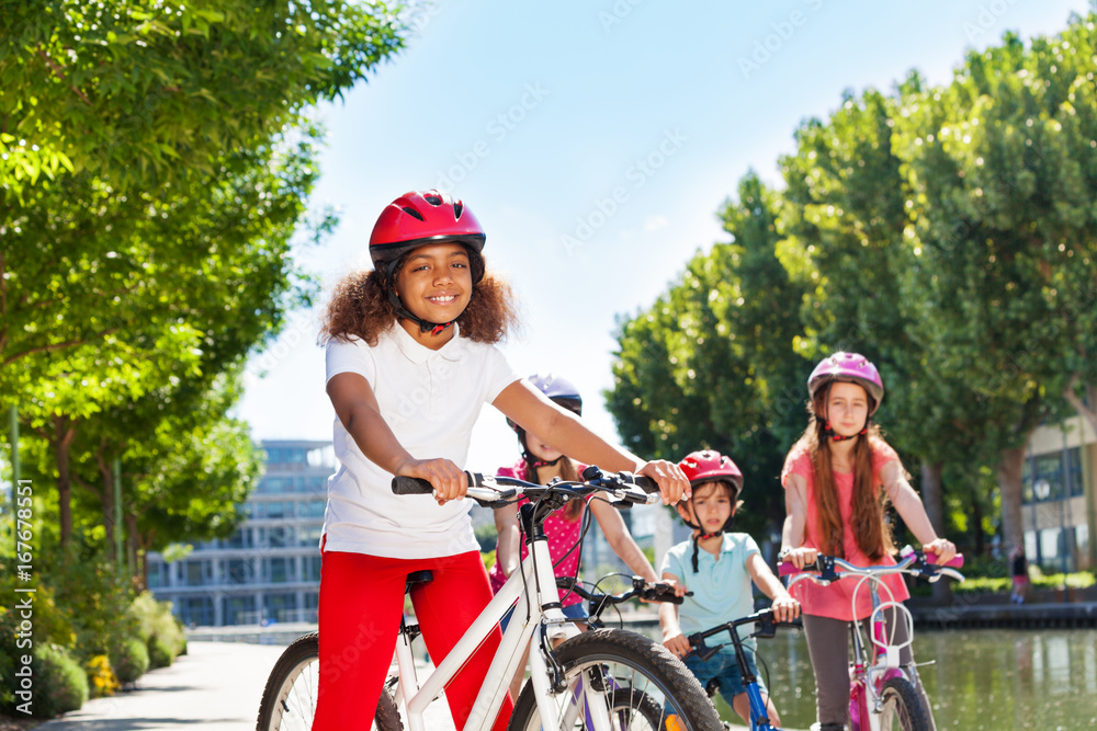 Obraz premium African girl cycling with friends at city park