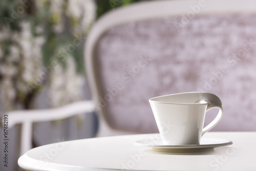 Fototapeta Naklejka Na Ścianę i Meble -  White cup and saucer. On a white table.