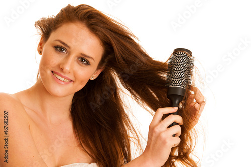 Beautiful young woman combs her hair with a brush isolated over white background