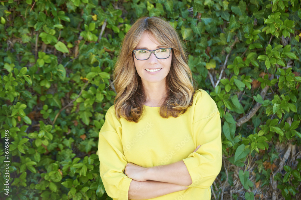 Loevely woman portrait. Close-up portrait of a smiling beautiful woman standing outdoor against leafy green background Loevely woman portrait. Close-up portrait of a smiling beautiful woman standing outdoor against leafy green background