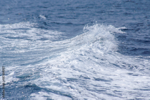 The wave of blue sea with foam on the surface made from boat engine