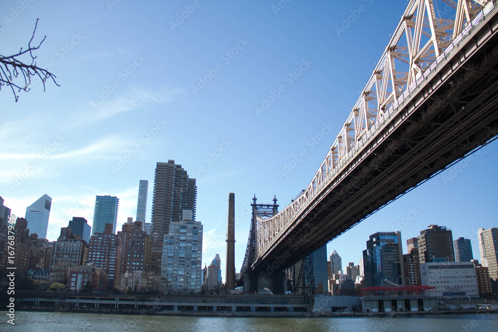 Fototapeta premium Most Queensboro nad rzeką i budynki na Manhattanie z błękitnym niebem