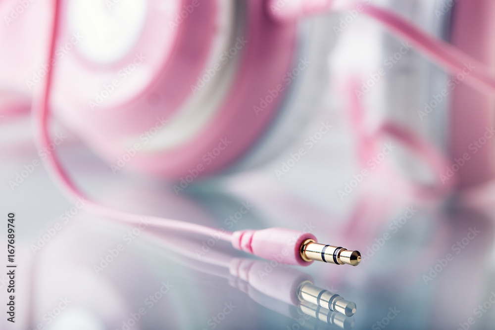 Headphones. Pink Headphones with jack connector - mirror reflection
