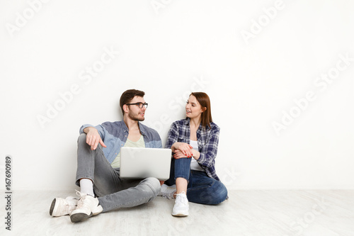Casual couple working with laptop, studio shot