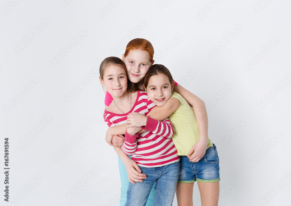 Portrait of three smiling girls at white studio background Portrait of three smiling girls at white studio background