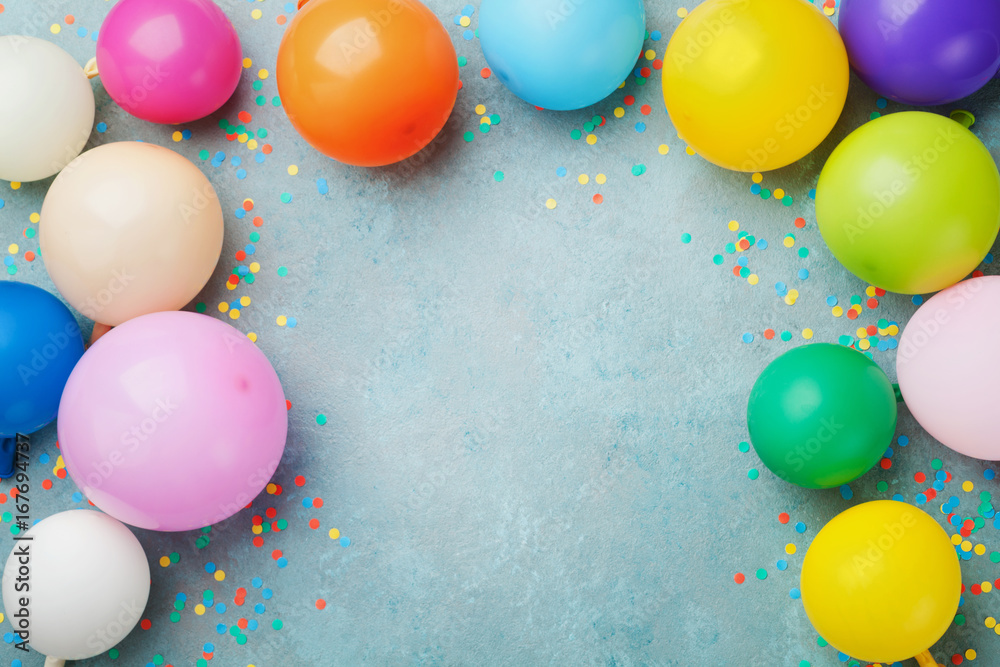 Colorful balloons and confetti on blue table top view. Festive or party background. Flat lay style. Copy space for text. Birthday greeting card. - obrazy, fototapety, plakaty 