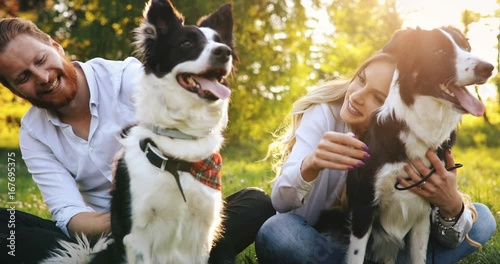 Beautiful couple cuddling and walking dogs outdoors