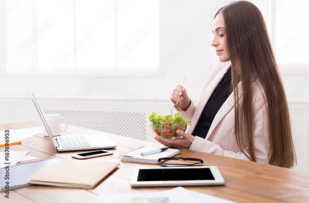 Young business woman eating salad at office Young business woman eating salad at office
