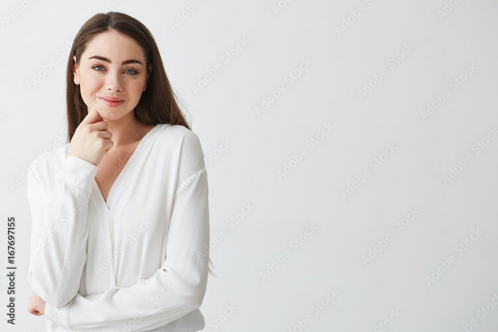 Portrait of young beautiful business lady looking at camera smiling touching face over white background. Portrait of young beautiful business lady looking at camera smiling touching face over white background.