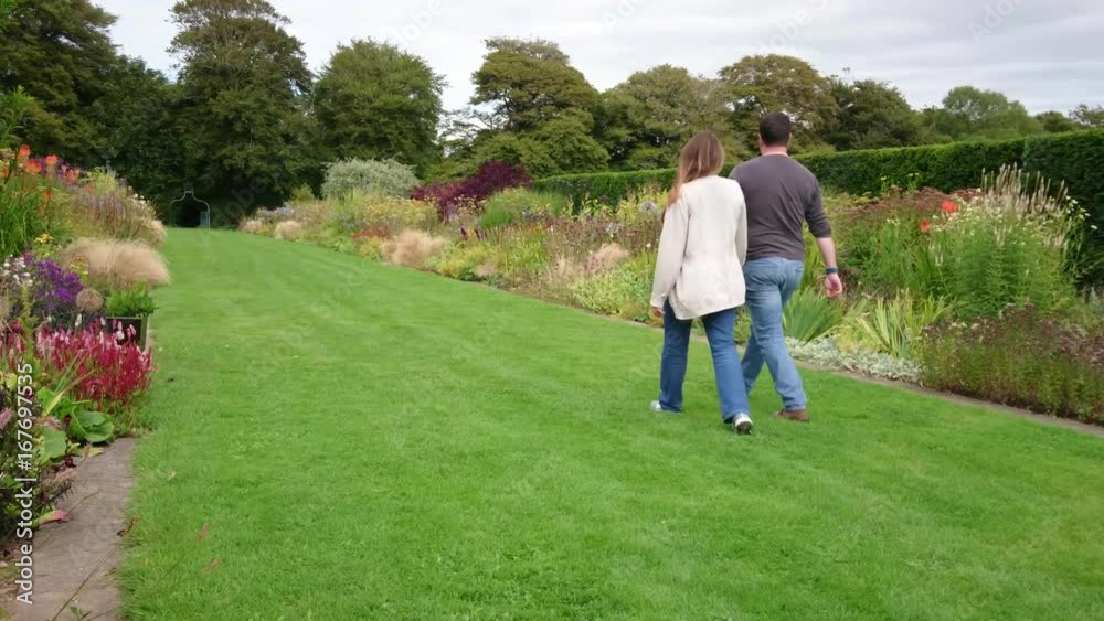 Couple walking and kissing in a flower garden Couple walking and kissing in a flower garden