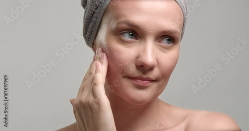 woman puts a cream on facer closeup. 30s woman