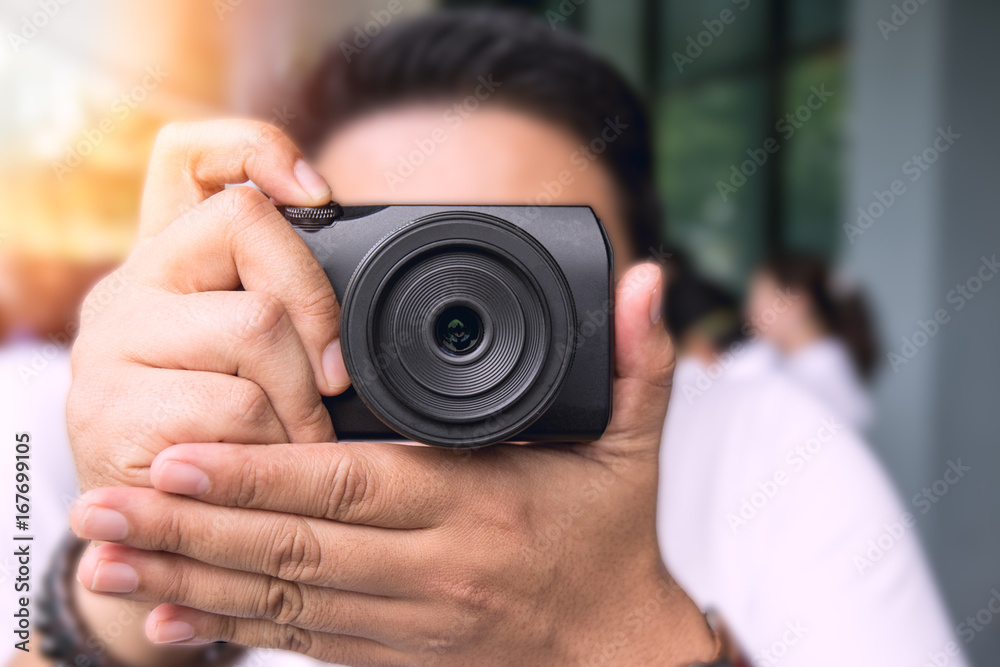 man aim and shoot digital camera with copy space and flare man aim and shoot digital camera with copy space and flare