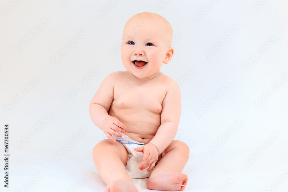 A happy baby is smiling on a light background. A cute boy. Emotions of a young child A happy baby is smiling on a light background. A cute boy. Emotions of a young child