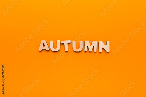 Word Autumn on orange background