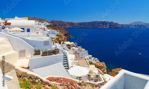 View from top on the Oia white architecture of the hotels and the sea. Santorini