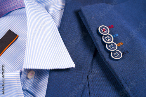 set of classic mens clothes - blue suit, shirts, brown shoes, belt and tie on wooden background.