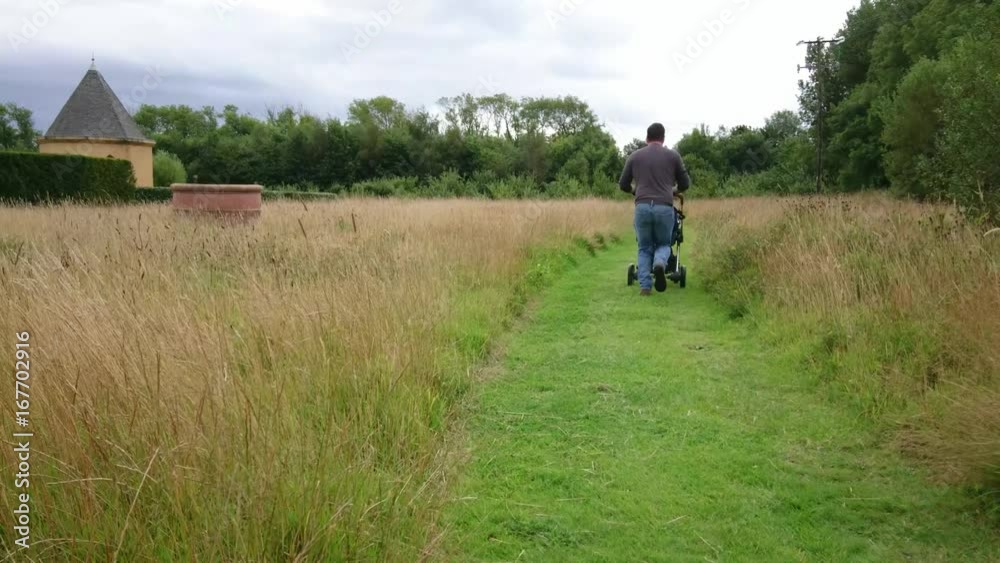 A man running with a pram through green space A man running with a pram through green space