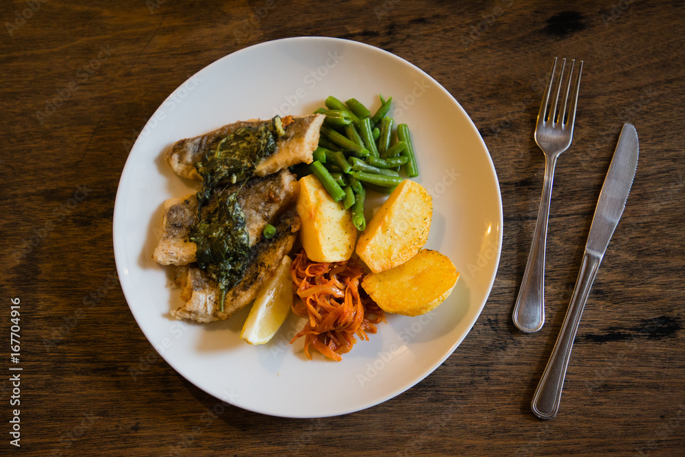 fish and chips plate with vegetables and lemon in a restaurant fish and chips plate with vegetables and lemon in a restaurant
