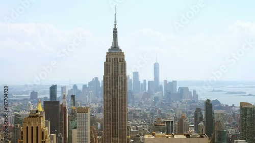 Aerial view on the city skyline in New York City, USA, on a warm sunny summer day with beautiful cloudy sky. A rotating video picturing concrete jungle, including the Empire State Building, Upper Bay. photo