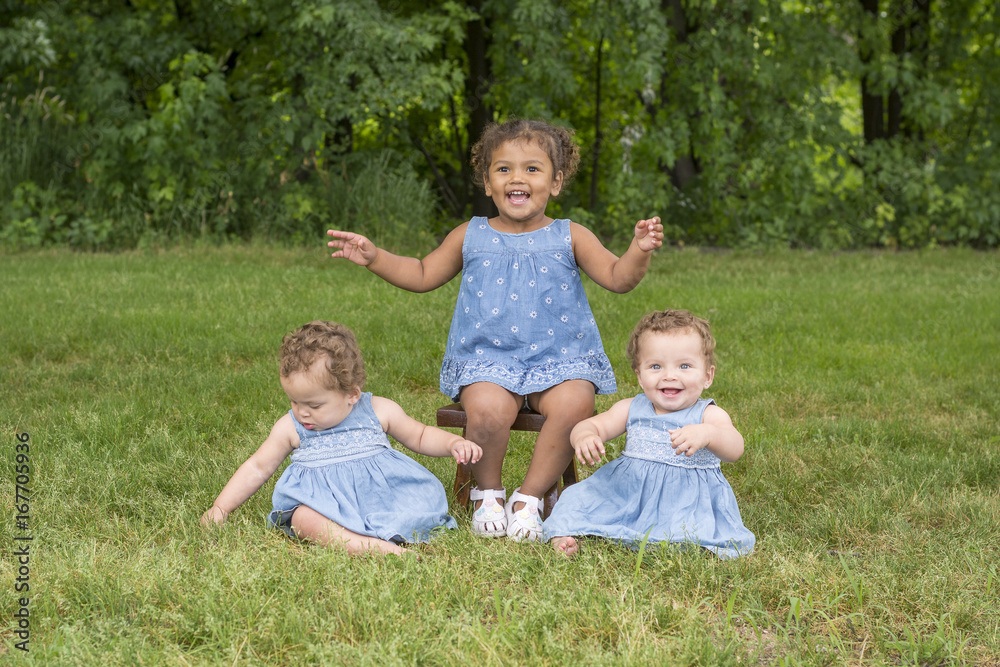 Identical twin girls with their big sister Identical twin girls with their big sister