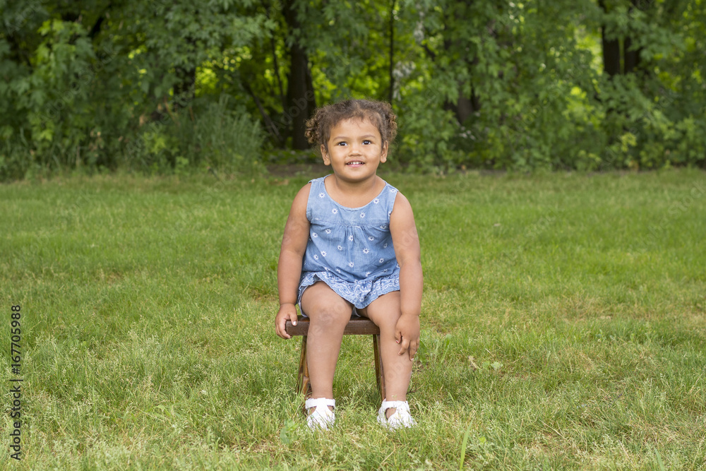 Adorable toddler girl sitting on a stool Adorable toddler girl sitting on a stool