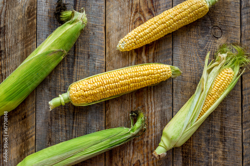Vegetarian food. Corn cobs on rustic wooden background top view