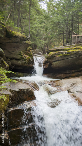 Water cascading down rocky hillside photo