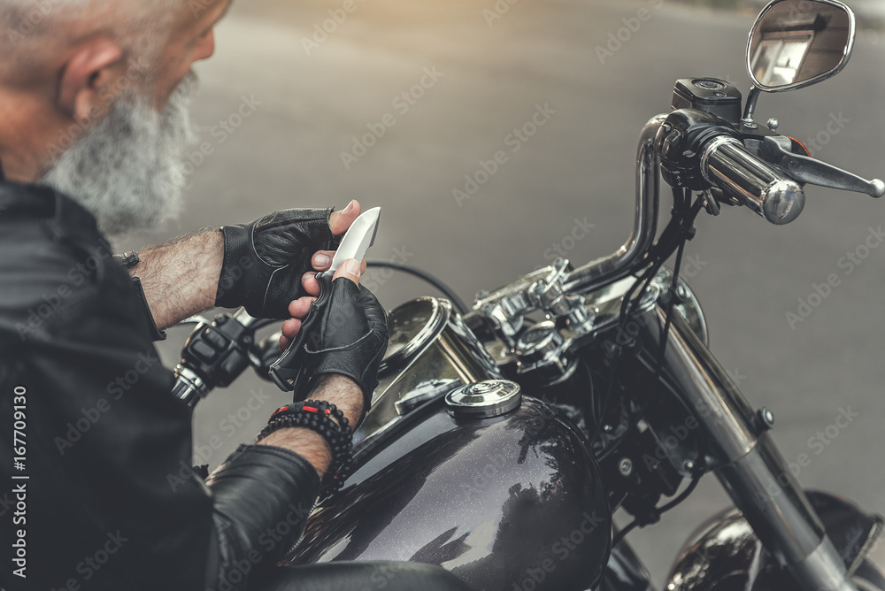 Aged man holding sharp blade Aged man holding sharp blade