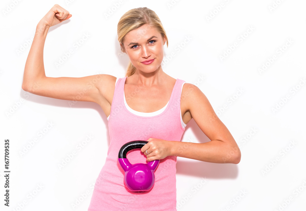 Happy young woman working out with a kettlebell Happy young woman working out with a kettlebell