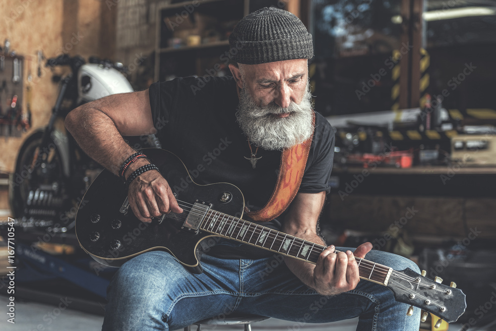 Fototapeta premium Concentrated elder man holding instrument