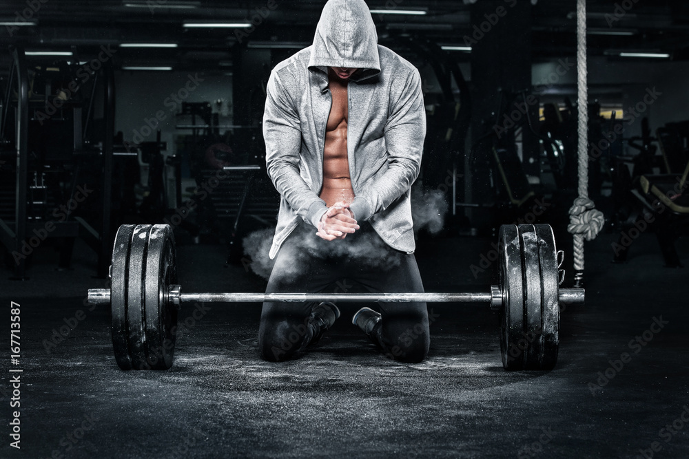 Muscular young fitness sports man workout with barbell in fitness gym Muscular young fitness sports man workout with barbell in fitness gym