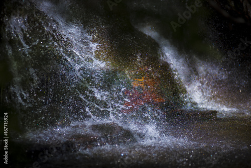 Colourful waterfall flowing on the stones