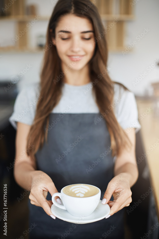Close up of perfect latte art cappuccino served by young but experienced female barista. Close up of perfect latte art cappuccino served by young but experienced female barista.