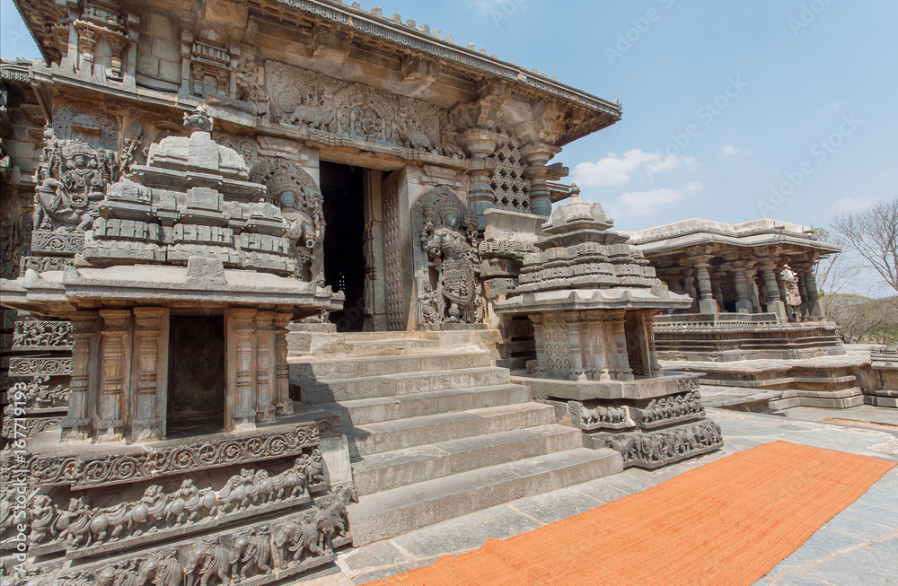 Entrance to ancient temple buildings of Halebidu, with carved walls and towers of the 12th century Hoysaleshwara temple, India.
