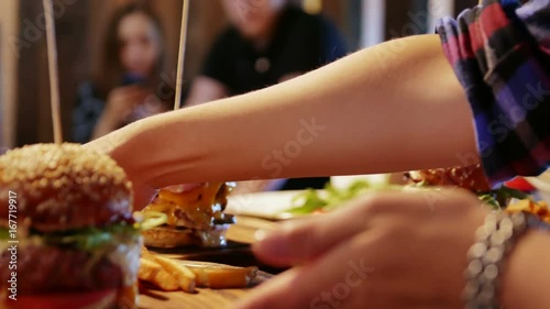 The waiter takes an American hamburger to the guest