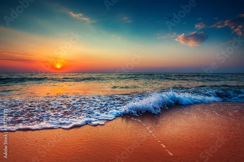 Obraz Piękny wschód słońca nad morzem i łamanie fal oceanicznych