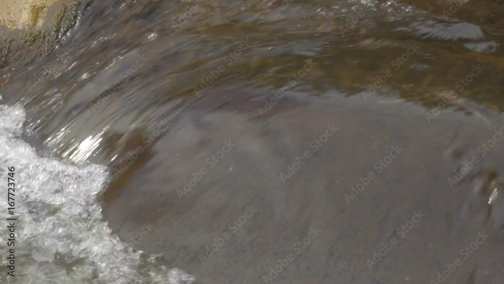 Clean fresh water stream running across stones Clean fresh water stream running across stones